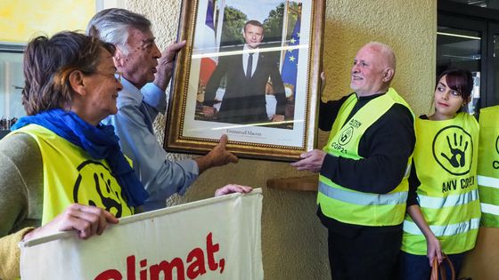 Militants décrochant le portrait d’Emmanuel Macron à la mairie de Cabestan, dans le sud-ouest de la France, le 27 février 2019. ©AFP - RAYMOND ROIG