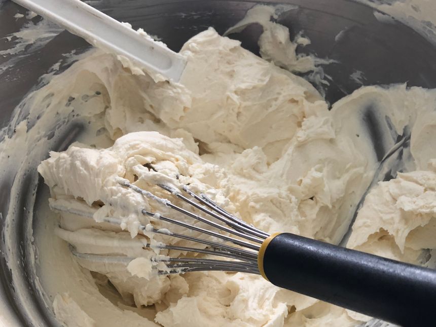 Une crème de mascarpone pour accompagner un gâteau normand, préparé au fouet par Philippe Batard à l'Auberge du Vieux Château à Saint-Sauveur-le-Vicomte (Manche). Août 2019.