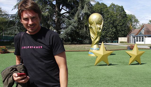 Guilermo Guiz devant la reproduction géante de la coupe du monde qui accueille les visiteurs à Clairefontaine