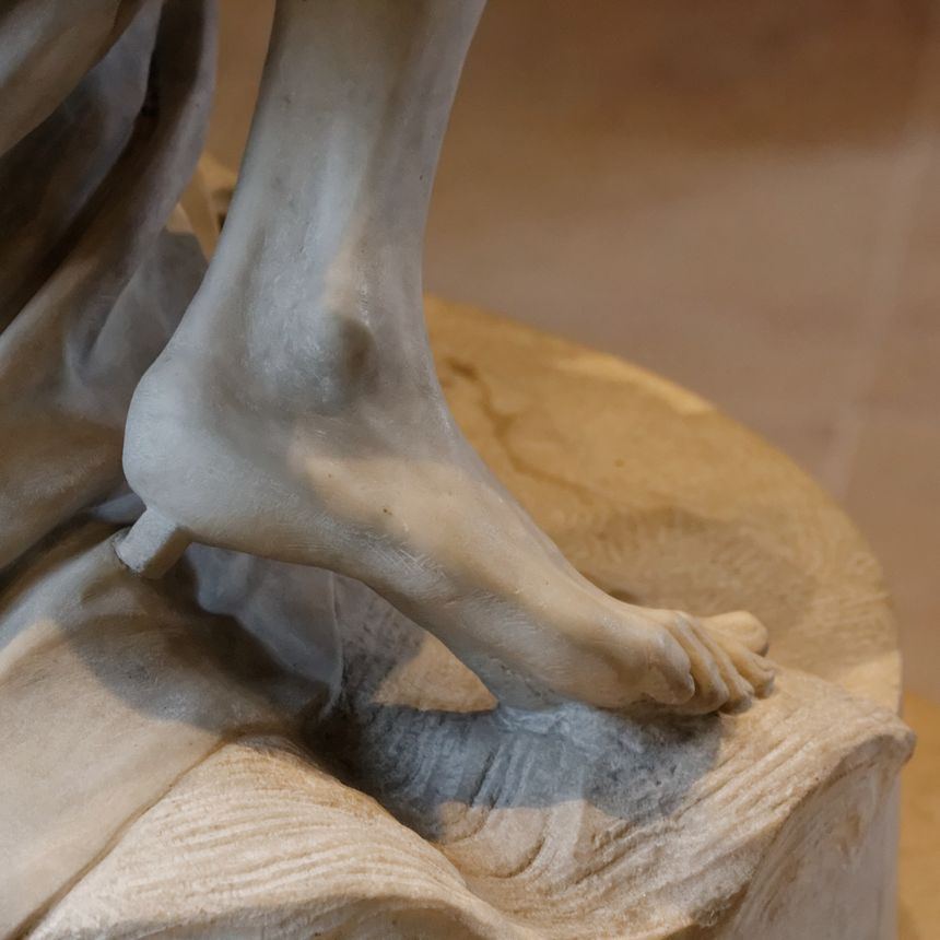 Le pied nu de la statue de Voltaire.