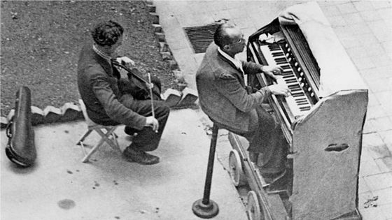 Berlin, scène de rue durant l'après-guerre, un joueur d'harmonium et un violoniste faisant de la musique - 29.06.1949 ©Getty - Walter Gircke Vintage property of ullstein bild (via Getty Images)
