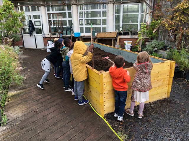Les élèves réunis autour du bac de permaculture sur le toit de l'école maternelle