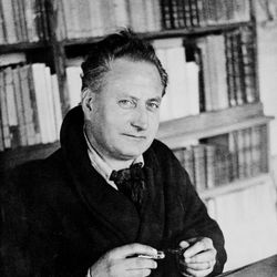 Portrait non-daté de l'écrivain français Jean Giono posant à son bureau à Paris.