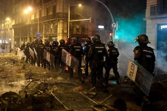 Des policiers dans une rue jonchée de débris à Barcelone, le 18 octobre.