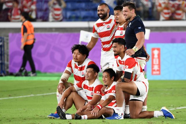 Le troisième ligne japonais Michael Leith (debout à gauche), après la victoire de son équipe face à l'Écosse