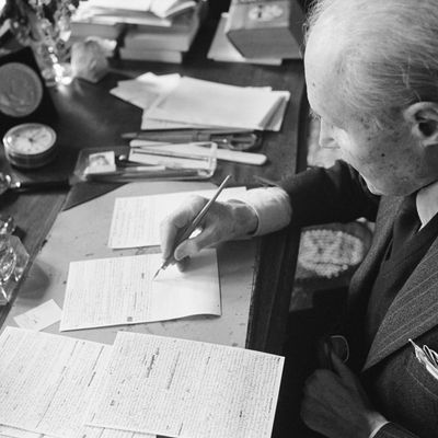 Maurice Genevoix écrivant à son bureau.