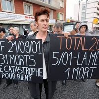 Une femme présente des panneaux sur lesquels figure le nombre des victimes de la catastrophe AZF alors qu'elle participe le 21 septembre 2009 à Toulouse à la cérémonie marquant le 8ème anniversaire de l'explosion de l'usine chimique AZF.