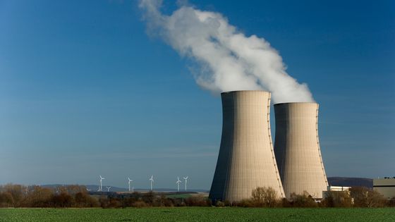 Deux tours de refroidissement avec en arrière-plan des éoliennes. ©Getty - RelaxFoto.de