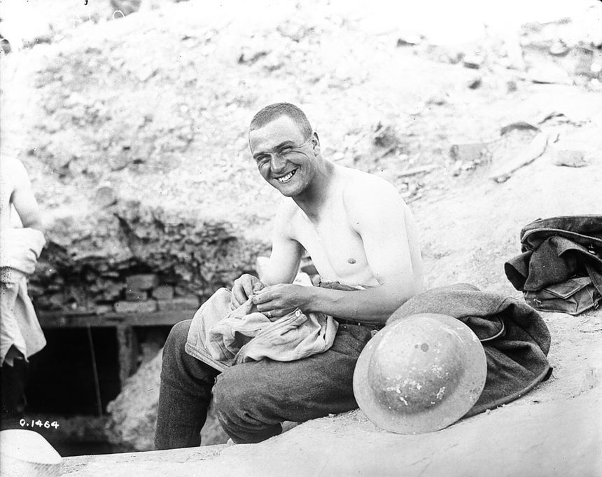 Canadien qui cherche des « cooties » (poux de corps) dans sa chemise en mai 1917.