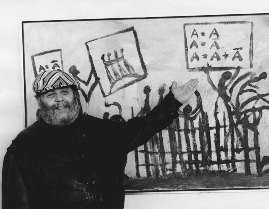 A.R. Penck devant l'une de ses œuvres à l'occasion d'une exposition à la Neue Nationalgalerie de Berlin, en avril 1988