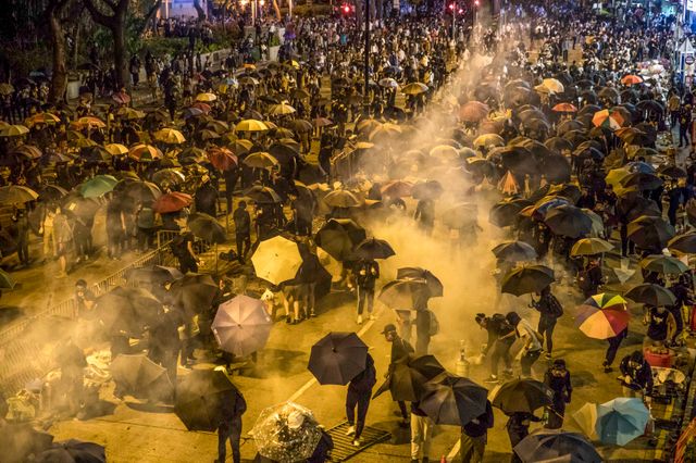 Des manifestants reçoivent du gaz lacrymogène après avoir tenté de pénétrer dans l'enceinte de PolyU pour venir en aide aux manifestants du campus