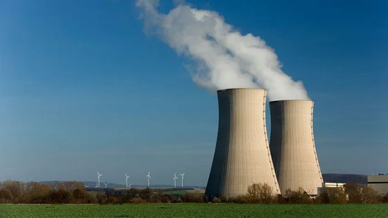 Deux tours de refroidissement avec en arrière-plan des éoliennes ©Getty - RelaxFoto.de
