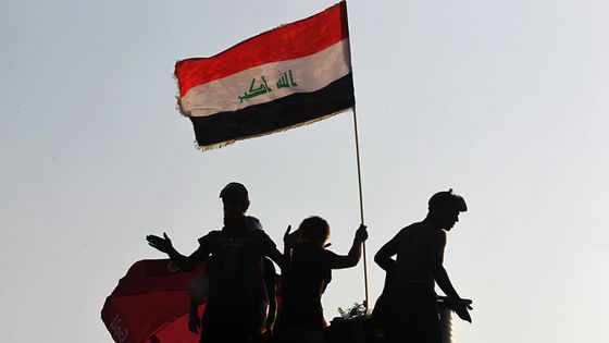 Sur la place Tahrir à Bagdad, les manifestants brandissent le drapeau irakien lors d'un rassemblement contre le gouvernement, le 30 octobre 2019 ©AFP - Ahmad al-Rubaye