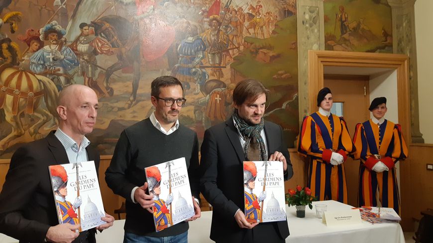 De gauche à droite, Yvon Bertrorello, co-auteur, Laurent Bidot, dessinateur, Arnaud Delalande, co-auteur et deux gardes suisses dans les quartiers de la Garde suisse pontificale au Vatican