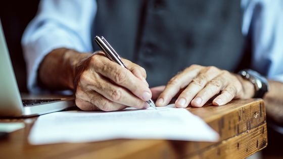 Un vieil homme signant un document ©Getty - Extreme Media