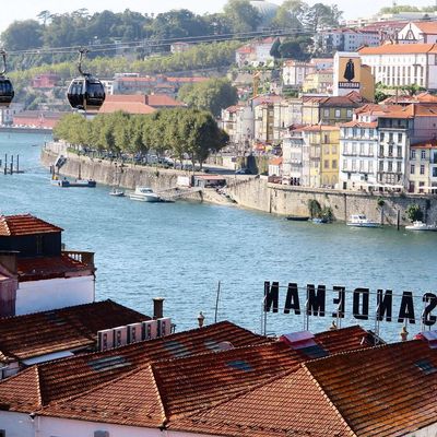 Le téléphérique urbain de Porto au-dessus des toits avec la publicité pour le porto Sandeman. Vue sur des façades de la ville. 19 Août 2019.