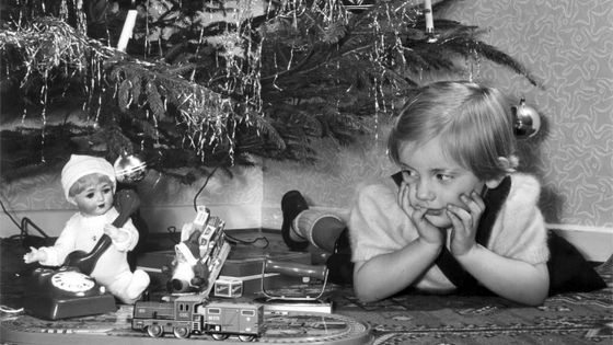 Petite fille anglo-saxonne contemplant ses cadeaux sous le sapin de Noël (1955) ©Getty - Otto Noecker