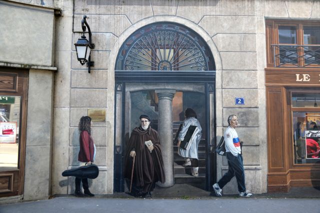 Bernard Lacombe peint sur la fresque des Lyonnais, à droite de l'Abbé Pierre