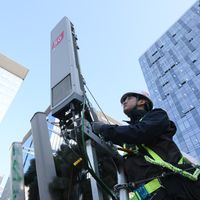 Un technicien sud-coréen s'occupe de la maintenance d'une antenne 5G au pied d'un building, à Séoul, le 4 avril 2019.
