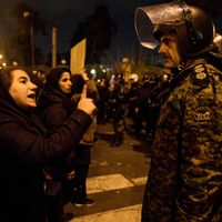 Manifestante iranienne tentant de dialoguer avec un policier, samedi 11 janvier, devant l’université Amirkabir de Téhéran. Dimanche, la police a utilisé des gaz lacrymogènes et tiré en l’air.