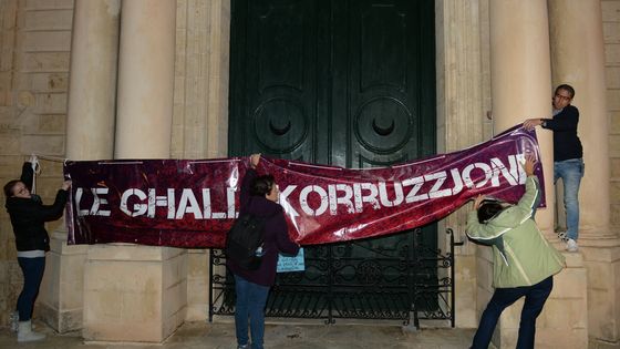 Des manifestants accrochant une bannière "Non à la corruption" à la porte du bureau du Premier ministre à la Valletta, à Malte, le 20 novembre 2019. ©AFP - Matthew Mirabelli