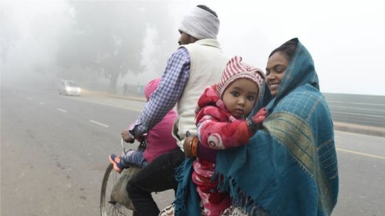 Famille indienne à bicyclette, chaudement vêtue en raison de températures anormalement froides. Le 30 décember 2019 à New Delhi, Inde. ©Getty - Arvind Yadav / Hindustan Times