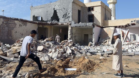 Des Libyens se trouvent sur le site où trois enfants sont morts lors de l'offensive de l'homme fort libyen, Khalifa Haftar, au sud de Tripoli, le 14 octobre 2019. ©AFP - Mahmud Turkia