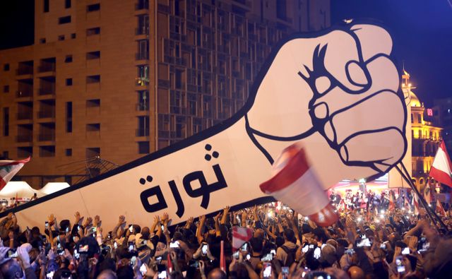 Manifestants libanais brandissant une pancarte "Révolution" sur la place des Martyrs à Beyrouth, le 22 Novembre 2019