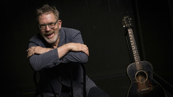 Portrait de Dick Annegarn, avec sa guitare, le 24 mars 2016 à Boulogne-Billancourt ©AFP - Martin Bureau