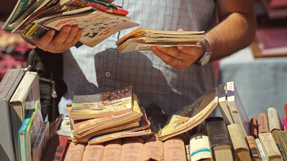 Un homme en train de chiner des bandes dessinées dans une brocante ©Getty - Davide Ronfini / EyeEm