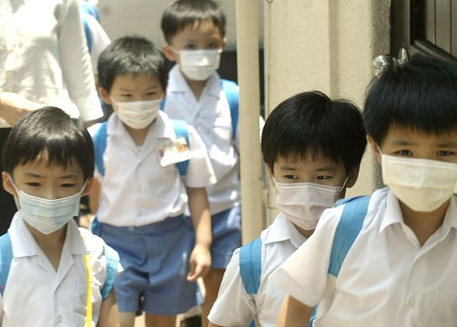 Des écoliers hongkongais portant des masques, en juillet 2003.