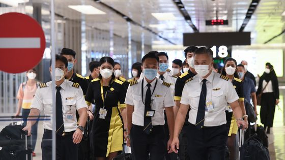 L'équipage de la compagnie aérienne Scoot qui s'est envolée pour Wuhan pour évacuer les ressortissants singapouriens arrive à l'aéroport international de Changi à Singapour. 30/01/2020 ©AFP - Roslan RAHMAN