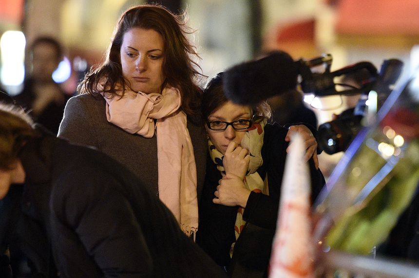 Deux personnes rendent hommage aux victimes des attentats, près du Bataclan le 14 novembre 2015.
