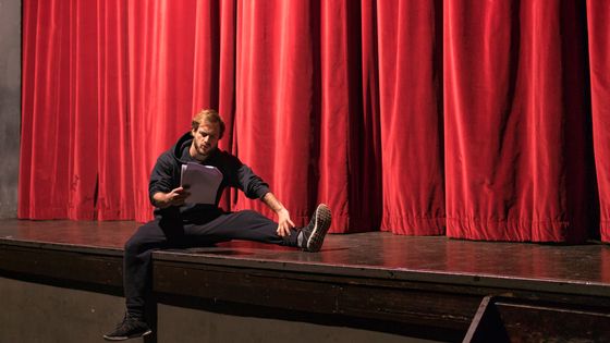 Acteur assis sur la scène du théâtre étudiant un scénario. ©Getty - Westend61