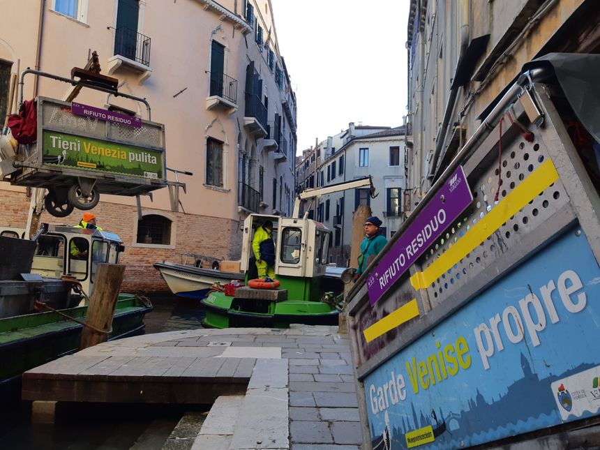 Le chariot est levé par le conducteur de la barque qui décharge sont contenu dans la cale avant de rejoindre une décharge sur une île.