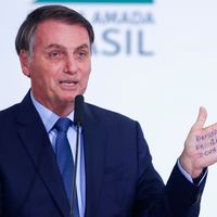 Le Président brésilien Jair Bolsonaro montrant l'inscription écrite sur sa main "Patrie, Famille, Dieu", lors d'une cérémonie pour fêter ses 400 jours à la tête du Brésil, le 5 février dernier