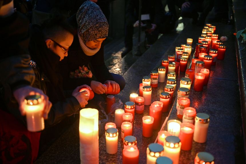 Des jeunes placent des bougies devant l'hôtel de ville de Kassel lors d'une commémoration pour les victimes de l'attentat.