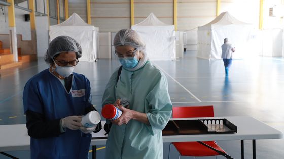 Le personnel médical vérifie l'équipement médical à l'intérieur d'un nouveau centre de diagnostic Covid-19 dans un gymnase de Taverny ©AFP - Ludovic MARIN