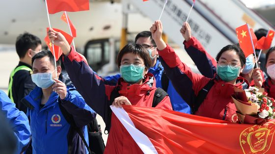 Entrée la première dans l’épidémie, la Chine en est aussi sortie la première : ici une équipe médicale envoyée en renfort à Wuhan rentre chez elle, dans la province de l’Anhui, accueillie en héros. ©AFP - Zhou Mu / XINHUA