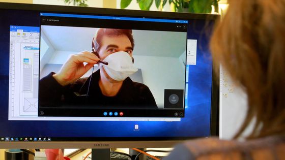 Salarié travaillant dans une TPE PME portant un masque de protection dans son entreprise et confiné à son domicile, en communication Skype avec son entreprise ©Maxppp - Philippe Lavieille