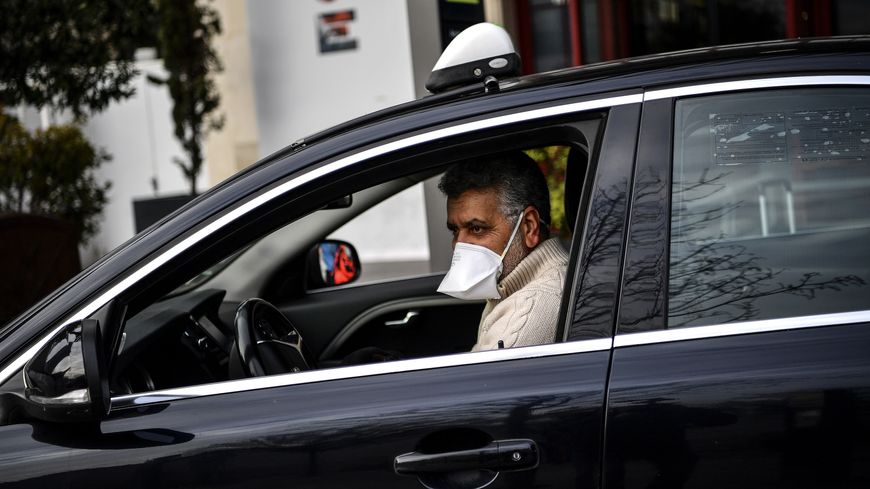 Malgré l'épidémie et le confinement généralisé, ils continuent de travailler : ici un chauffeur de taxi Gare d'Austerlitz à Paris le 17 mars.