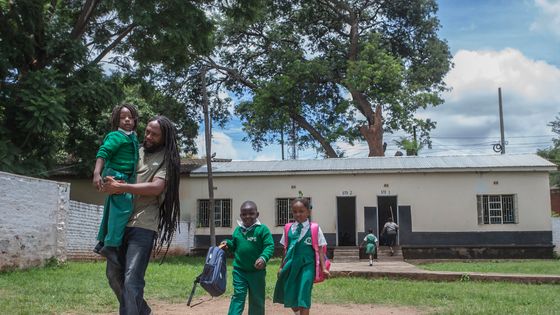 Un père rasta et ses enfants devant une école privée à Lilongwe, le 30 janvier 2020. ©AFP - AMOS GUMULIRA