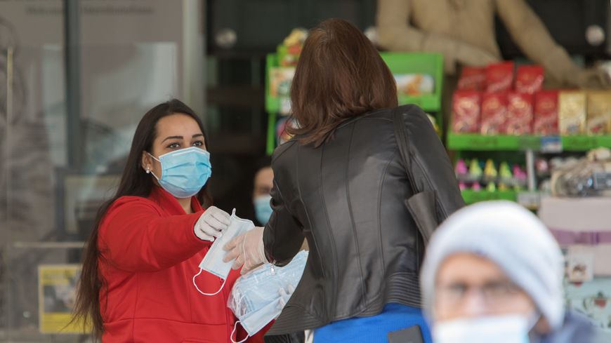 À Vienne, en Autriche, l'employée d'un supermarché distribue des masques de protection