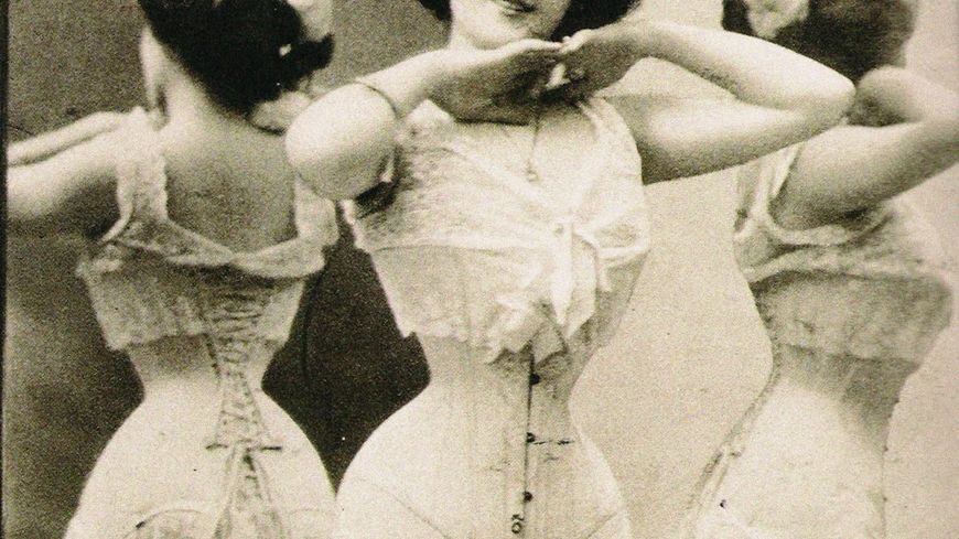 Une femme montre son corset de style victorien à la fin des années 1890.