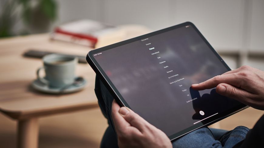 Homme qui fait défiler des noms sur sa tablette