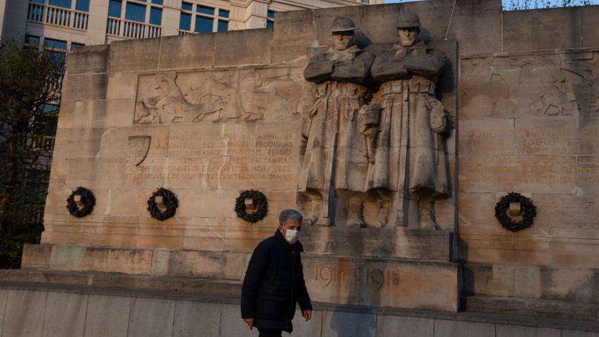 Un homme portant un masque passe devant le mur du souvenir consacre aux soldats de la guerre 14-18 (Bruxelles, 07/04/2020 )