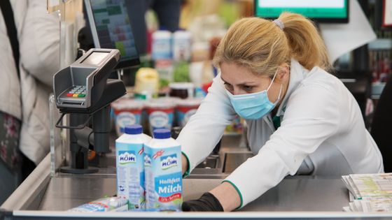 Une caissière repoussant la menace du coronavirus ©AFP - Alex Halada
