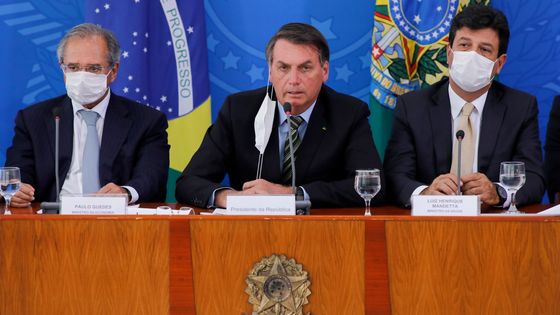 Jair Bolsonaro au centre et le ministre de la Santé Mandetta à sa gauche, le 18/03/20 à Brasilia ©AFP - Sergio LIMA