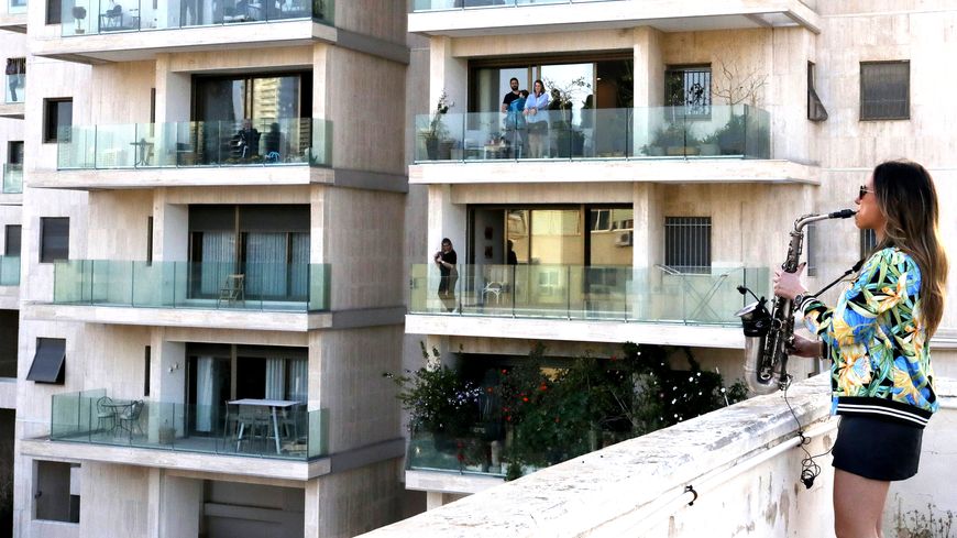 La saxophoniste Yarden Klayman joue sur le toit d'un immeuble à Tel Aviv, en Israël, après l'annulation de son concert en raison du coronavirus, le 23 mars 2020.