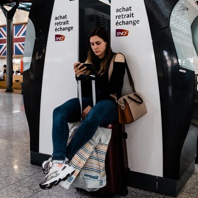 Une jeune femme assise sur sa valise attend son train, à Paris, le 23 avril.